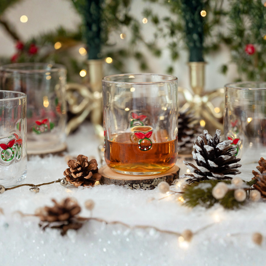 Glass with a drink on a snowy surface with Christmas decorations