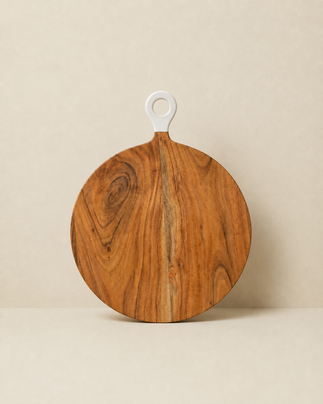 Round wooden serving board with a white hanging loop handle, displayed on a neutral beige background.