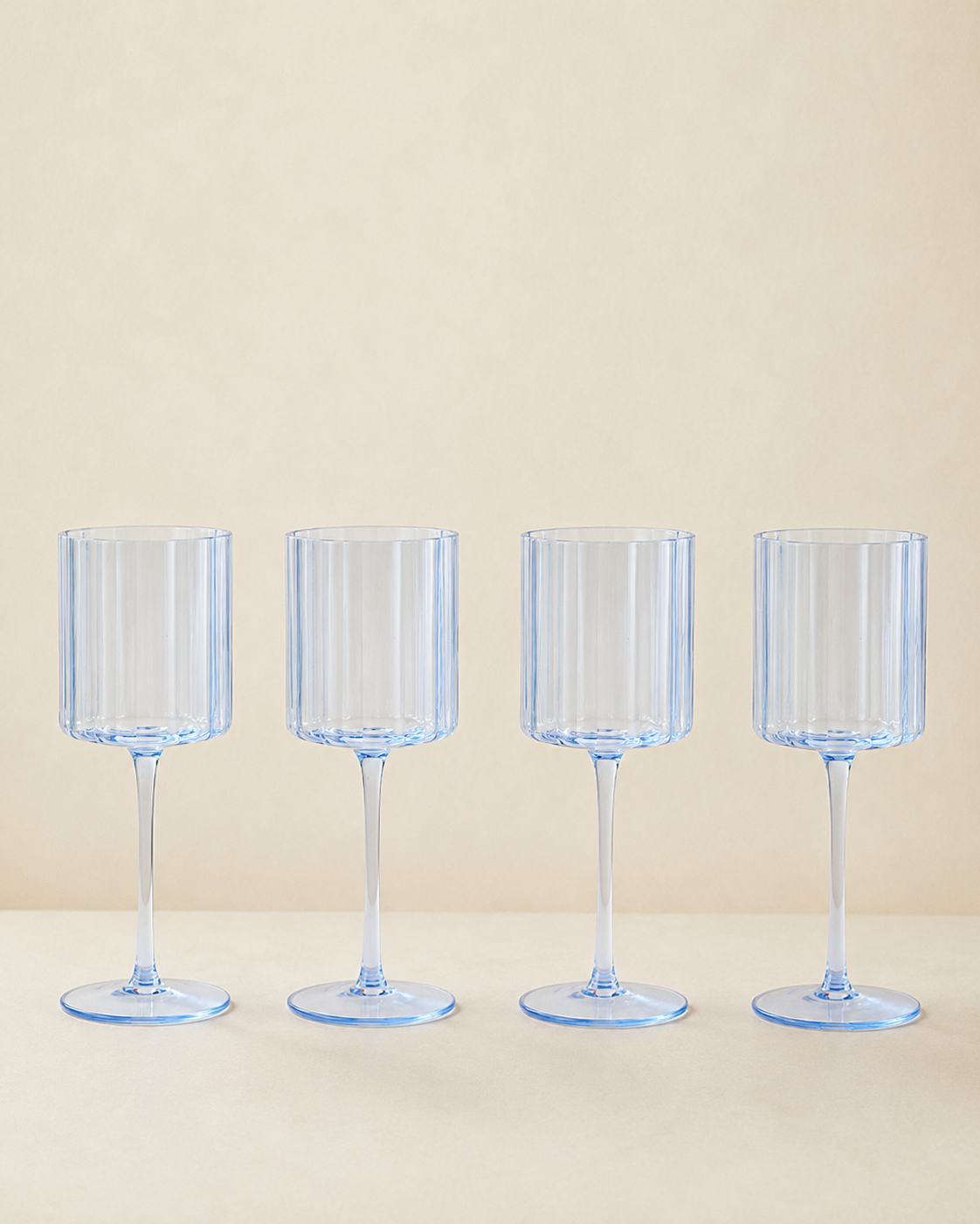Set of 4 Blue Scalloped Glasses on a Cream Background