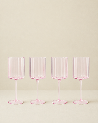 Set of 4 pink scalloped glasses on a cream background
