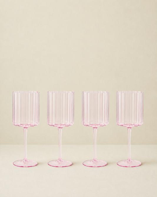 Set of 4 pink scalloped glasses on a cream background