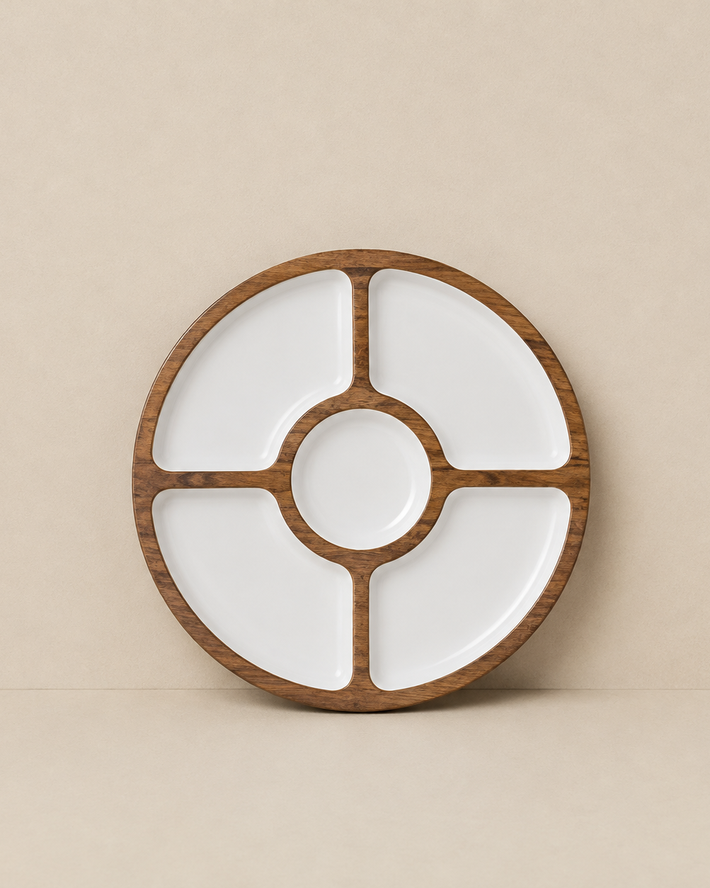 A round wooden serving platter with four white compartments and a central well, shown against a solid beige background.